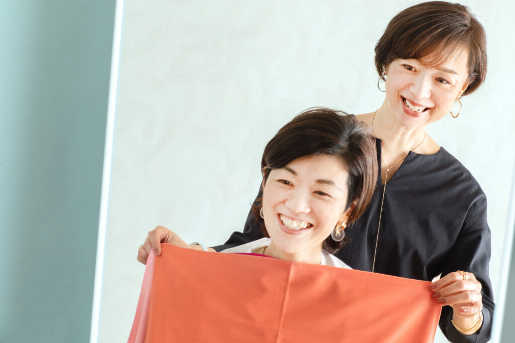 カラー診断で色の布を当てながら、似合う色や印象を言葉で確認している様子